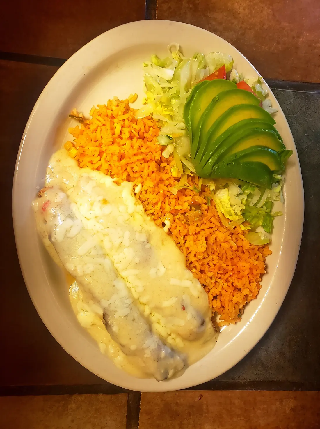 A hot dinner plate of Tex-Mex food served at Taco El Conquistador in Bullard, Texas