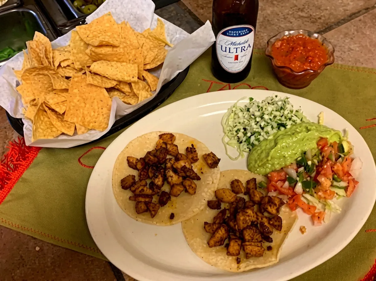 Three soft tacos with cilantro, onion and guacamole, served with chips and salsa